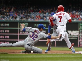 New York Mets starting pitcher Steven Matz (32) drops the ball trying to tag out Washington Nationals Trea Turner (7) at first base during the first inning of baseball game, at Nationals Park, Saturday, April 7, 2018 in Washington. Looking on is New York Mets first baseman Wilmer Flores (4).