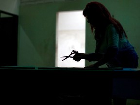 In this April 12, 2018 photo, Betty Maidana works on cutting cloth to make green handkerchiefs at a cooperative in Buenos Aires, Argentina. Maidana says green is for hope and that the handkerchief in Argentina means years of fighting, citing the Mothers of Plaza de Mayo who wear white handkerchiefs. The green handkerchief has become the symbol of the pro-abortion movement.