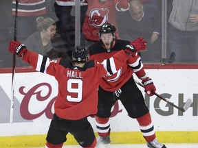 New Jersey Devils right wing Stefan Noesen, right, celebrates his goal against the Tampa Bay Lightning with teammate Taylor Hall (9) during the third period of Game 3 of an NHL first-round hockey playoff series, Monday, April 16, 2018, in Newark, N.J. The Devils won 5-2.