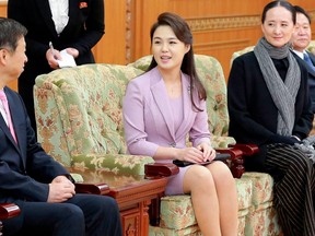 In this April 14, 2018, photo provided by the North Korean government, Ri Sol Ju, center, wife of North Korean leader Kim Jong Un, talks with Song Tao,  left, head of the ruling Communist Party's International Department, in Pyongyang, North Korea.