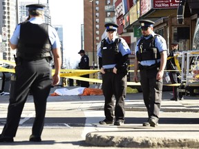 Police secure an area around a covered body in Toronto after a van mounted a sidewalk crashing into a number of pedestrians on Monday, April 23, 2018.