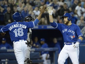 Toronto Blue Jays catcher Russell Martin (55) celebrates with teammate Curtis Granderson (18) after hitting a two-run home run during seventh inning American League baseball action in Toronto on Monday, April 2, 2018.