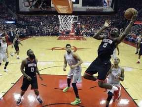 Houston Rockets' Clint Capela shoots over Minnesota Timberwolves' Jeff Teague (0) and Karl-Anthony Towns (32) during the first half in Game 1 of a first-round NBA basketball playoff series Sunday, April 15, 2018, in Houston.