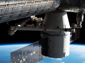 In this image provided by NASA, the Dragon capsule arrives at the International Space Station on Wednesday, April 4, 2018 with food and experiments. It will remain attached to the orbiting outpost for about a month, returning to Earth in May. Dragon launched Monday from Cape Canaveral, Florida, aboard a used Falcon rocket. SpaceX wants to reduce launch costs by recycling rocket parts.  (NASA via AP)