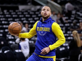 FILE - In this April 19, 2018 file photo, Golden State Warriors guard Stephen Curry (30) warms up before Game 3 of the team's first-round NBA basketball playoff series against the San Antonio Spurs in San Antonio.  Curry has been cleared to take part in modified practices but will be out at least one more week with a left knee injury. The Warriors said Curry was examined by the team's medical staff Friday and is making progress in recovering from the grade 2 left MCL sprain that has sidelined him since March 23.