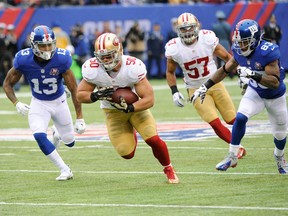 FILE - In this Nov. 16, 2014, file photo, San Francisco 49ers inside linebacker Chris Borland (50) runs back an interception as New York Giants' Odell Beckham (13) and Preston Parker (83) give chase during an NFL football game in East Rutherford, N.J. Borland knows firsthand all about the challenges of early retirement, having stepped away from a promising football career after one year because of concerns over head injuries. Borland spends his time now helping other football players and military veterans make that adjustment to their new lives that often lack the thrill and competitiveness of life in the armed forces or professional sports.