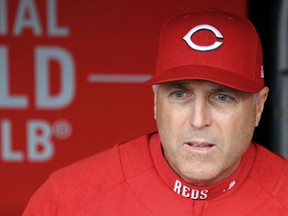 FILE - In this April 14, 2018, file photo, Cincinnati Reds' manager Bryan Price stands in the dugout prior to a baseball game against the St. Louis Cardinals, in Cincinnati. The Reds have fired Bryan Price after a 3-15 start, the first managerial change in the major leagues this season. Price was in his fifth season leading the rebuilding team. The Reds have lost at least 94 games in each of the last three seasons while finishing last in the NL Central. Bench coach Jim Riggleman will manage the team on an interim basis.