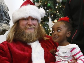 FILE - In this Dec. 4, 2015, file photo, Lian Taylor, 2, of Bayonne, N.J., sits on the lap of New York Jets center Nick Mangold, posing as Santa Claus during the team's holiday party for military families in Florham Park, N.J. Former New York Jets center Nick Mangold has announced his retirement from playing football after 11 seasons in which he established himself as one of the NFL's best at his position. The 34-year-old Mangold announced on Twitter on Tuesday morning, April 17, 2018, that he will sign a one-day contract with the Jets to retire as a member of the team.