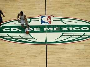 FILE - In this Jan. 14,2017, file photo, San Antonio Spurs Kawhi Leonard dribbles the ball past the middle of the court as Phoenix Suns P.J. Tucker follows in the second half of their regular-season NBA basketball game in Mexico City. An NFL team in London? An NBA franchise in Mexico City? We're drawing closer to the day when a team from those leagues puts down roots outside the United States and Canada.