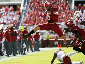 FILE - In this Oct. 7, 2017, file photo, Oklahoma quarterback Baker Mayfield (6) leaps over Iowa State defensive back De'Monte Ruth, bottom, in the second quarter of an NCAA college football game in Norman, Okla. Mayfield is expected to be a first round pick in the NFL Draft.