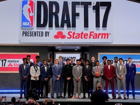 FILE - In this June 22, 2017, file photo, top draft prospects gather for a group photo before the NBA basketball draft in New York. The commission proposing reforms to college basketball wants 18-year-olds to be eligible again for the NBA draft, and the NBA Players Association would make that deal today. Change will take longer than that. NBA Commissioner Adam Silver senses the league's age limit isn't working. Requiring U.S. players to be 19 years old and one year removed from high school has sent many of them to a year of college they don't want, and delayed the full-time basketball instruction pro teams prefer. But whether the league would agree to allow players to come straight from high school again, or want them to wait two years before becoming draft eligible, has been a sticking point practically since the age limited was enacted in 2005 and remains unclear now.
