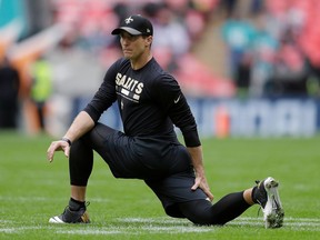 FILE - In this Oct. 1, 2017, file photo, New Orleans Saints quarterback Drew Brees stretches before the team's NFL football game against Miami Dolphins at Wembley Stadium in London. Brees has filed suit accusing a California businessman of cheating him out of $9 million through jewelry purchases.