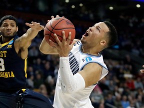 FILE - In this March 23, 2018, file photo, Villanova's Jalen Brunson, right, drives against West Virginia's James Bolden (3) during the first half of an NCAA men's college basketball tournament regional semifinal, in Boston. Brunson, The Associated Press men's college basketball player of the year, has declared for the NBA draft after winning two national titles at Villanova.