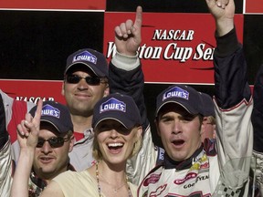 FILE - In this July 20, 2003, file photo, Jimmie Johnson celebrates with his girlfriend, Chandra Janway, after his victory in the Nascar New England 300 at New Hampshire International Speedway in Loudon, N.H.  Lowe's is leaving the sport after 18 years as the only Cup Series sponsor Johnson has ever had, and his rights are for sale for the first time.  Eighty-three victories in that Lowes-branded No. 48 Chevrolet. (AP Photo/File)