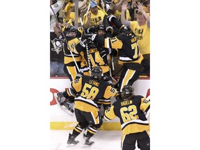 FILE - In this May 10, 2016, file photo, Pittsburgh Penguins' Nick Bonino (13), center, is mobbed by teammates after scoring the game winning goal against the Washington Capitals during overtime of Game 6 of the NHL hockey Stanley Cup Eastern Conference semifinals, in Pittsburgh. The Penguins and Capitals are facing off in the second round for the third consecutive year with the cast of characters changing only slightly along the way.