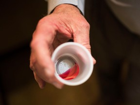 FILE - In this March 7, 2017, file photo, the CEO of a methadone clinic holds a 35 mg liquid dose of methadone in Rossville, Ga. The drug is the oldest and most effective of approved medications used to treat opioid addiction, but Medicare doesn't cover it.