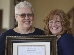 In this March 4, 2018 photo provided by the Ad Council, Mindy Beall, left, and her wife, Jimmie Beall, pose for a photo with their marriage certificate at their home in Columbus City, Ohio. Jimmie said she was fired from her job as a teacher because she is a lesbian.