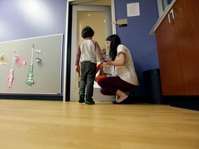 FILE - In this Monday, Oct. 24, 2016 file photo, Megan Krail helps a 4-year-old boy with Autism Spectrum Disorder practice trick-or-treating at The University of Texas at Dallas' Callier Center for Communication Disorders preschool class in Dallas. According to a report by the Centers for Disease Control and Prevention released on Thursday, April 26, 2018, the estimate of how common autism is again going up slightly, after seeming to level off for a couple of years.