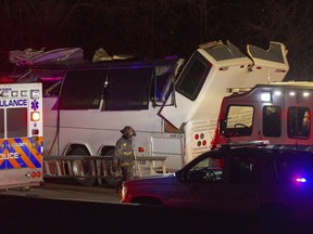 Police and firefighters respond to the scene of a charter bus accident on the eastbound Southern State Parkway in Lakeview, N.Y., Sunday, April 8, 2018. A charter bus carrying teenagers has struck a bridge overpass on Long island, mangling the entire length of the top of the bus.