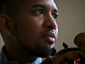 In this March 28, 2018 video still, Venezuelan musician Wuilly Arteaga holds his violin during an interview, in New York. The young violinist gained fame after playing somber renditions of Venezuela's national anthem during the 2017 protests.