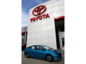 In this Sunday, April 15, 2018, photo an unsold 2018 Prius sits on a Toyota dealer's lot in the south Denver suburb of Englewood, Colo. Toyota says it will start equipping models with technology to talk to other vehicles starting in 2021, as it tries to push safety communications forward.