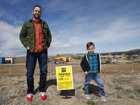 In this Saturday, April 7, 2018, photo, Chad Zolman, left, joins his 5-year-old son, Quinten, in standing at the site of their yet-to-be-constructed new home in Castle Rock, Colo. A tight housing market, further complicated by climbing interest rates and rising prices, has forced buyers such as Zolman to move farther out of the Denver metropolitan area. Zolman eventually bought a newly built, three-bedroom townhome for $370,000.