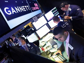 FILE - In this Aug. 5, 2014, file photo, specialist Michael Cacace, foreground right, works at the post that handles Gannett on the floor of the New York Stock Exchange. Maribel Perez Wadsworth has been named publisher of USA Today, becoming the second woman to hold the post. USA Today announced the appointment in statement Thursday, April 5, 2018.