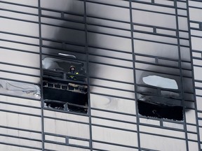 A firefighter looks out from the window of a fire damaged apartment in Trump Tower in New York on  Saturday, April 7, 2018.