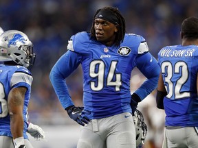 FILE - In this Oct. 23, 2016, file photo, Detroit Lions defensive end Ezekiel Ansah stands in the sideline during the first half of an NFL football game against the Washington Redskins in Detroit. Ansah has signed his franchise tag, signaling his return to the Detroit Lions, the team announced Tuesday, April 17, 2018. Detroit designated the defensive end from Ghana as its franchise player nearly two months ago.