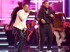 FILE - In this Jan. 28, 2018 file photo, Luis Fonsi, left, and Daddy Yankee perform "Despacito" at the 60th annual Grammy Awards in New York. "Despacito" and other popular music videos were the target of a security breach on the video sharing service Vevo. The cover image of the Luis Fonsi/Daddy Yankee hit was replaced by an image of masked people pointing guns. Clips by Taylor Swift, Drake, Selena Gomez and Shakira also were affected. A YouTube spokesperson says the company worked with its partner to disable access after seeing "unusual upload activity" on some Vevo channels.