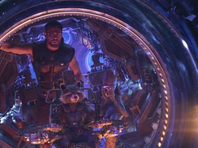 This image released by Marvel Studios shows Chris Hemsworth as Thor. with characters Rocket, voiced by Bradley Cooper, seated center, and Groot, voiced by Vin Diesel, in a scene from "Avengers: Infinity War." (Marvel Studios via AP)