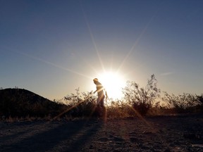 FILE - In this June 16, 2017, file photo, a man runs through section of South Mountain Park at sunrise to avoid the excessive heat in Phoenix. National Weather Service meteorologists say Phoenix Sky Harbor International Airport reached the triple-digit mark about 3 p.m. Tuesday, April 10, 2018, due to a strong area of high pressure over the region.