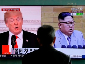 FILE - In this March 27, 2018, file photo, a man watches a TV screen showing file footages of U.S. President Donald Trump, left, and North Korean leader Kim Jong Un during a news program at the Seoul Railway Station in Seoul, South Korea. A Trump administration official said Sunday, April 8, that the United States has now "confirmed that Kim Jong Un is willing to discuss the denuclearization of the Korean Peninsula." The official wasn't authorized to be quoted by name and demanded anonymity. The meeting could occur as early as May.