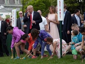 FILE - In this April 17, 2017, file photo, President Donald Trump, accompanied by first lady Melania Trump, blows a whistle to begin an Easter Egg Roll race on the South Lawn of the White House in Washington during the annual White House Eastern Egg Roll.