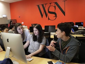In this Sunday, April 22, 2018, photo, New York University's Washington Square News editor-in-chief Jemima McEvoy, left, talks to deputy managing editor Pamela Jew, center, and managing editor Sayer Devlin, while preparing the weekly's next edition on deadline, in New York. McEvoy has been forced to cut the newspaper by four pages and slice circulation. With the Save Student Newspapers movement, college journalists are speaking up for themselves in a coordinated campaign to combat some of the same forces that have battered newspapers across the country as digital media has imperiled print.
