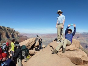 FILE - In this March 16, 2015, file photo, hikers stop and take photos along the Grand Canyon National Park's South Kaibab trail. With diverse landscapes and abundant wildlife, America's national parks are popular travel destinations. To save money on a trip, break out the camping gear and schedule your visit around a fee-free day or during off-peak time.