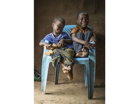 In this April 16, 2018 photo, three-year-old Shukri Muhamed, left, and her brother Ibrahim, 6, share a chair at their home at the Kakuma Refugee Camp in Kakuma, Kenya, where they live with their mother Saido Muhina Khamis. Khamis thought she'd be in the United States by now, starting a new life with her mother and her own family, but instead, the Somali woman is still at the camp, where she has been since 2009.