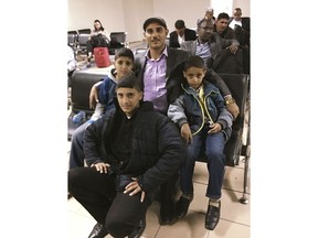 In this Jan. 21, 2018 family photo provided by Radad Alborati, center in cap, he poses for a photo with his sons, from left, Mohsin, 14, Mohammad, 16, and Sakr (9 at the time, 10 now), at an airport in Djibouti, as they wait for a flight that would bring the boys to live in the U.S. Alborati was relieved to get visas for his sons while the travel ban was temporarily blocked by a court, but their mother is stuck in war-torn Yemen due to the ban and the boys are bunking with three separate sets of family friends because Alborati doesn't want to leave them home alone during his midnight-to-noon workdays.