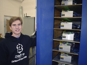 In this March 24, 2018 photo, Ryan Brienza poses with the drives at his crypto-mine in Plattsburgh, N.Y. Cheap electricity and chilly air near New York's northern border is attracting energy-hungry businesses that "mine" bitcoins and other digital currencies with rows of computers. But the small number of mines operating so far have created few jobs even as they tap into limited supplies of cheap hydro-power. While the direct number of jobs associated with mines can be small, Brienza said they can bring revenue, investments and talent to the city while employing local contractors.