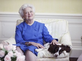FILE - In this 1990 file photo, first lady Barbara Bush poses with her dog Millie in Washington. A family spokesman said Tuesday, April 17, 2018, that former first lady Barbara Bush has died at the age of 92.
