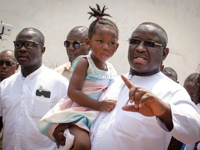 FILE - In this Saturday March 31, 2018, file photo, Julius Maada Bio, right, presidential candidate for the main opposition Sierra Leone People's Party, gestures outside before casting his ballots during the runoff presidential elections, outside a polling station in Freetown, Sierra Leone. On Wednesday, April 4, 2018, Sierra Leone's election commission declared Bio as the West African nation's new president, giving the opposition party its first presidency in 10 years.