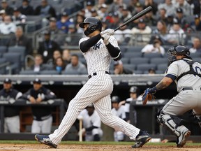 New York Yankees' Giancarlo Stanton (27) watches his first-inning, two-run, home run, his first at Yankee Stadium as a Yankee, in a baseball game against the Tampa Bay Rays in New York, Wednesday, April 4, 2018.