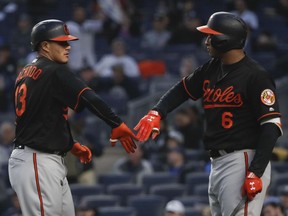 Baltimore Orioles' Manny Machado (13) is greeted by Jonathan Schoop (6) after hitting a solo home run against the New York Yankees during the first inning of a baseball game Friday, April 6, 2018, in New York.