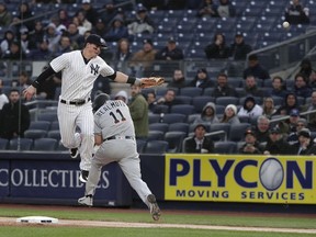 New York Yankees first baseman Tyler Austin can't come up with the wide throw from shortstop Didi Gregorius, allowing Miami Marlins' J.T. Realmuto (11) to reach first base safely and Starlin Castro to score during the first inning of a baseball game Tuesday, April 17, 2018, in New York.