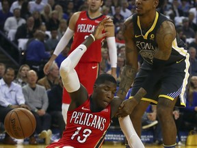 Golden State Warriors' Quinn Cook, right, breaks the fall of New Orleans Pelicans' Cheick Diallo (13) during the first half of an NBA basketball game Saturday, April 7, 2018, in Oakland, Calif.