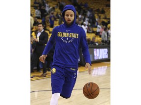 Golden State Warriors' Stephen Curry warms up prior to Game 1 of a first-round NBA basketball playoff series against the San Antonio Spurs Saturday, April 14, 2018, in Oakland, Calif.