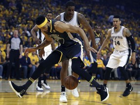 Golden State Warriors' JaVale McGee loses the ball between his legs in front of San Antonio Spurs' LaMarcus Aldridge during the first quarter in Game 2 of a first-round NBA basketball playoff series Monday, April 16, 2018, in Oakland, Calif.