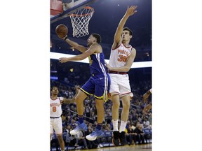 Golden State Warriors' Klay Thompson, left, drives past Phoenix Suns' Dragan Bender (35) during the first half of an NBA basketball game Sunday, April 1, 2018, in Oakland, Calif.