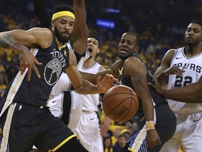 Golden State Warriors' JaVale McGee, left, and Andre Iguodala watch a loose ball beside San Antonio Spurs' Rudy Gay (22) during the first quarter in Game 2 of a first-round NBA basketball playoff series Monday, April 16, 2018, in Oakland, Calif.