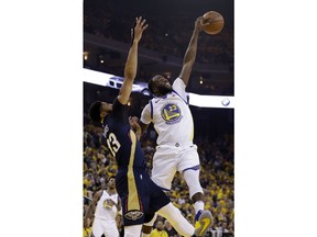 Golden State Warriors' Draymond Green, right, blocks a high pass intended for New Orleans Pelicans' Anthony Davis, left, during the first half in Game 1 of an NBA basketball second-round playoff series Saturday, April 28, 2018, in Oakland, Calif.